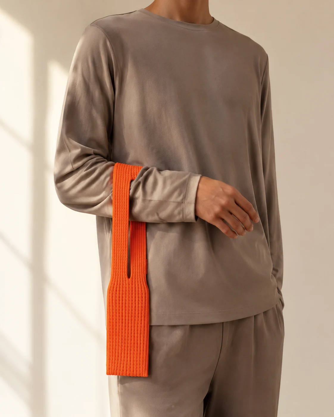 Pochette Courte orange portée au poignet